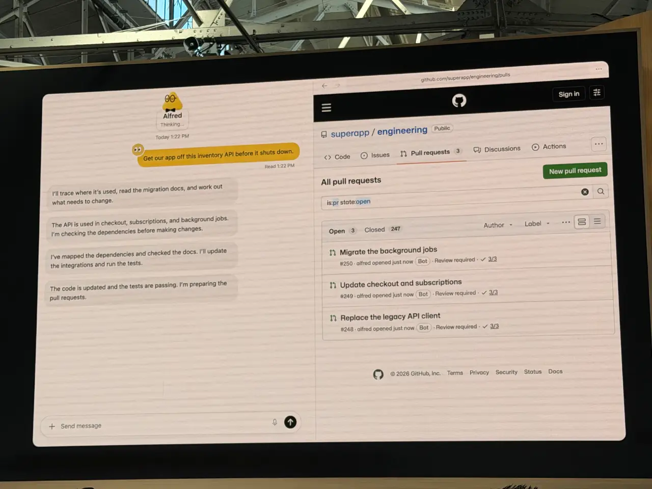 工业风格场地的大屏幕上展示着 Alfred 的对话以及公开的“superapp/engineering”GitHub 仓库页面。Alfred 被要求在库存 API 关闭前将其移除，随后它报告了追踪用法、检查依赖项、更新集成并通过测试的过程；GitHub 上列出了三个未合并的 pull request：“迁移后台任务”、“更新结账和订阅”以及“替换旧 API 客户端”。